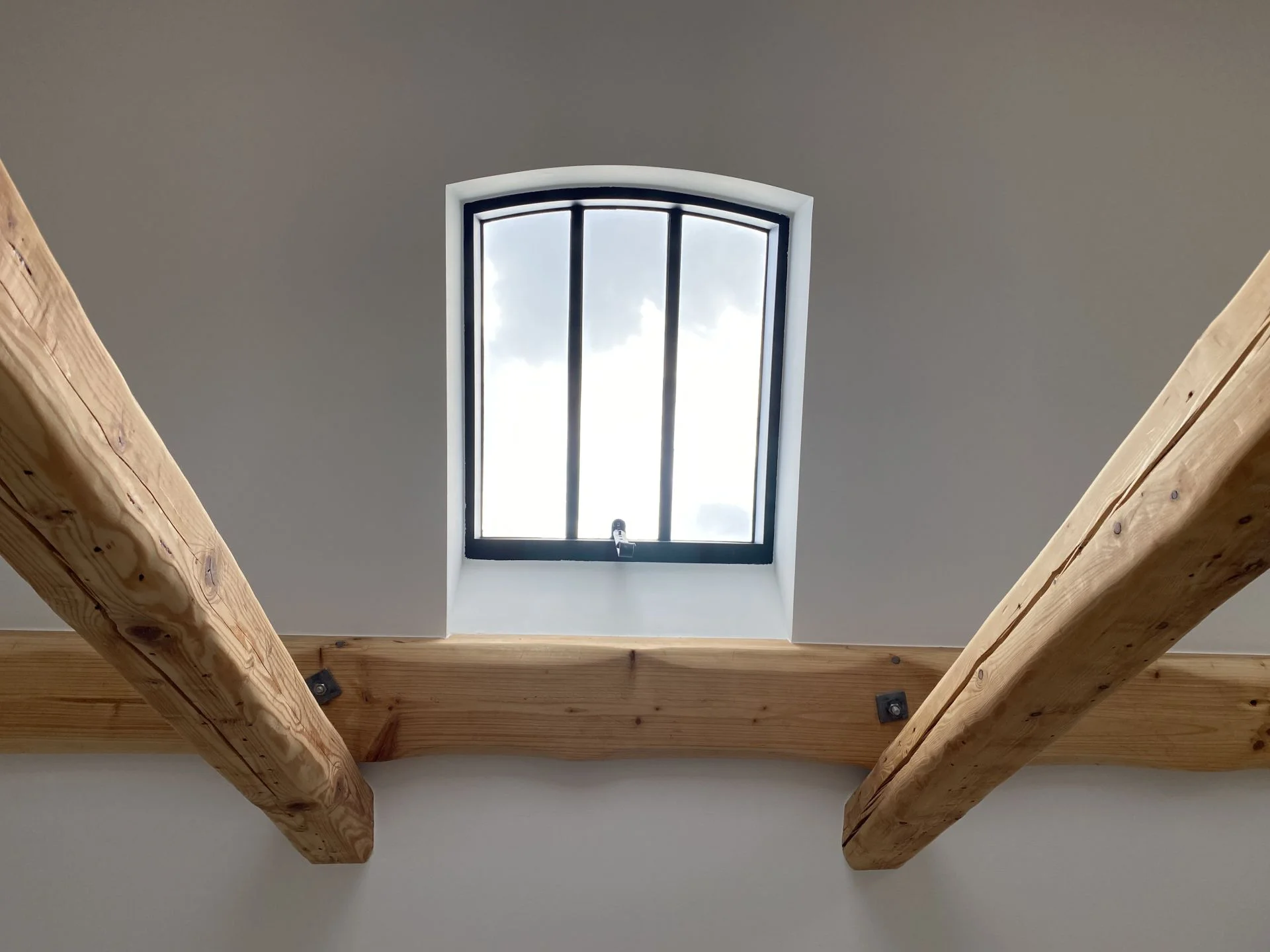 Dachfenster zwischen Holzbalken im Dachgeschoss